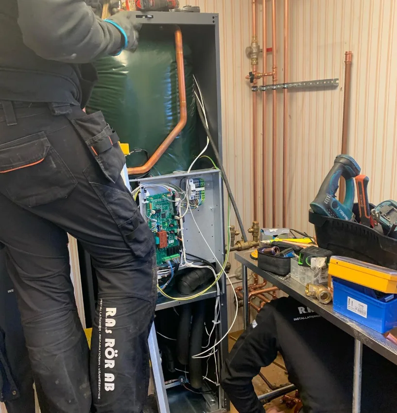 Pågående installation av värmepump med två anställda som installerar