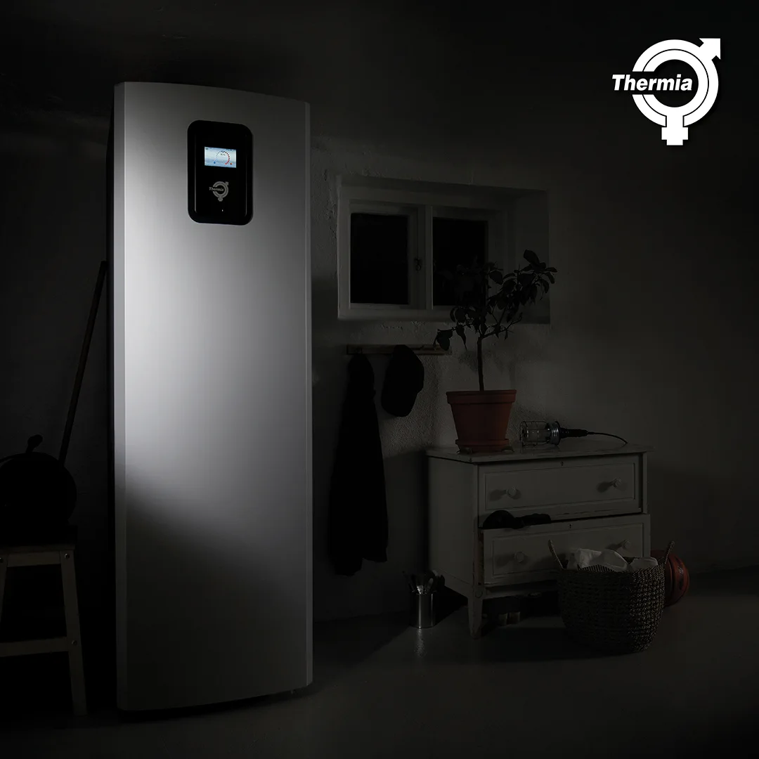 Bergvärmepump placerad i ett hem, mörk bild där bergvärmepumpen lyser fram