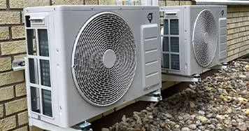 Två värmepumpar luft vatten som är placerad på ett tegelhus utsida 